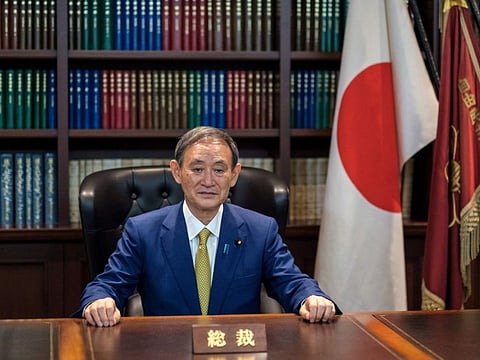 In this file photo taken on September 14, 2020 then newly elected leader of Japan's Liberal Democratic Party (LDP) Yoshihide Suga poses for a portrait at his office. 