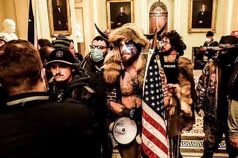 Jacob Chansley, a former actor and Navy sailor dubbed the “QAnon Shaman,” and other rioters invade the US Capitol in Washington on January 6, 2021. 