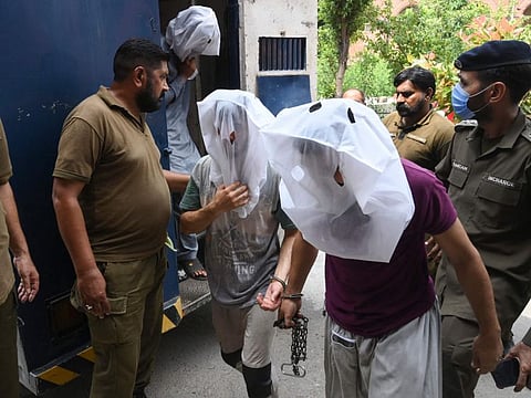 Police escort men as they are brought to a local court for allegedly groping and harassing a female TikToker in a public park on the Pakistan's Independence Day, in Lahore.