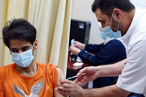 A man is inoculated with a dose of the Pizer-BioNTech vaccine against the coronavirus at Al Siddeeq health centre, in Kuwait City. Kuwait gradually starts opening up the country as the health situation is improving steadily.