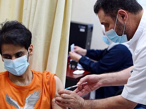 A man is inoculated with a dose of the Pizer-BioNTech vaccine against the coronavirus at Al Siddeeq health centre, in Kuwait City. Kuwait gradually starts opening up the country as the health situation is improving steadily.