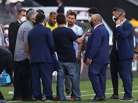 Chaotic scenes... Argentina's Lionel Messi and Brazil's Neymar speak to health officials who interrupted the game.