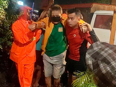A man is evacuated to safer ground after floodwaters continued to rise due to typhoon at Ormoc City, Leyte.