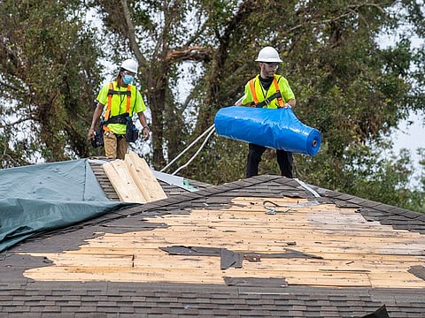 Roofing contractors install a temporary roof on a home in New Orleans East on Wednesday, Sept. 8, 2021.