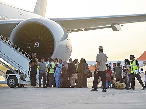 Passengers prepare to board a Qatar Airways aircraft at the airport in Kabul on September 9, 2021. Some 200 passengers, including US citizens, left Kabul airport on September 9, 2021, on the first flight carrying foreigners out of the Afghan capital since a US-led evacuation ended on August 30. 