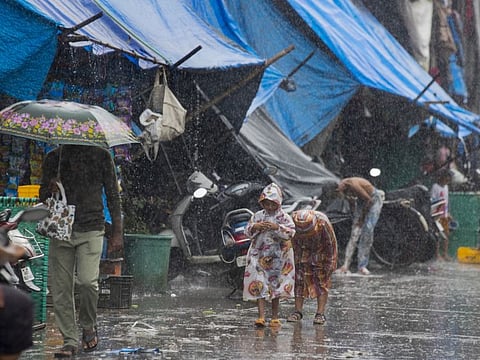People walk in a slum as it rain in Mumbai, on September 8, 2021. More than 4 million people in India are homeless, according to official data, with about 75 million living in slums and informal settlements in urban areas.