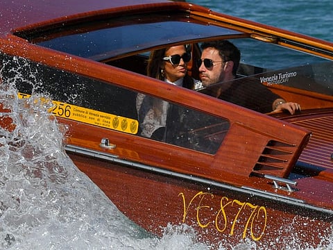 US actor Ben Affleck and US actress and singer Jennifer Lopez travel aboard a vaporetto taxi boat on September 9, 2021 after they arrived to attend the 78th Venice Film Festival in Venice.
