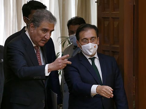 Pakistan’s Foreign Minister Shah Mahmood Qureshi, left, indicates the standing position to his Spanish counter part José Manuel Albares while they arrive for a joint press conference, in Islamabad, on September 10, 2021. 