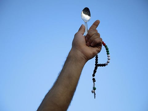 A protester holds a spoon, which has become a symbol celebrating the six Palestinian prisoners who recently tunnelled out of Gilboa Prison, in Umm Al Fahm, Israel, on September 10, 2021. 