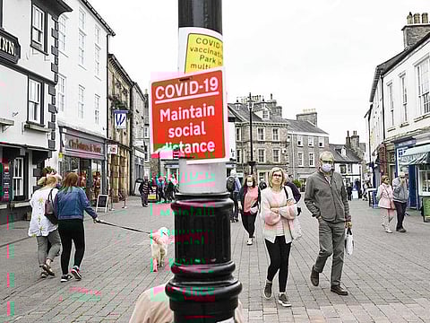 In this file photo taken on June 21, 2021 Members of the public, some wearing face coverings due to COVID-19, walk past shops in Kendal in Cumbria, north west England on June 21, 2021, where surge testing has been deployed following an outbreak of a coronavirus variant of concern. 