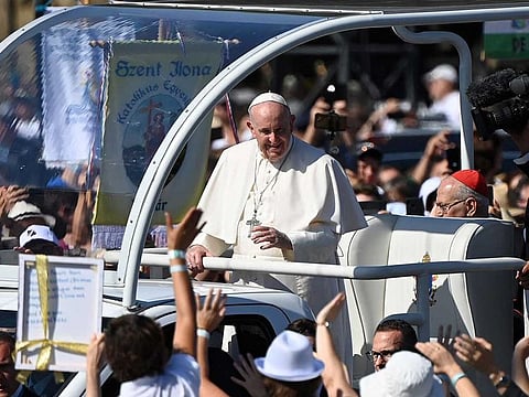 Pope Francis greets faithful as he arrives in an open vehicle for a Holy Mass at the end of an International Eucharistic Congress in Budapest on September 12, 2021, during his papal visit to Hungary.
