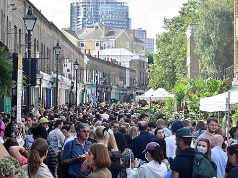 Crowds of people walk along Columbia Road flower market in east London on September 12, 2021. British officials said that COVID-19 vaccines have saved more than 112,000 lives and averted 24 million cases of the disease as they recommended all vulnerable people, frontline health staff and those aged over 50 be offered a booster shot, starting with the oldest and most vulnerable.