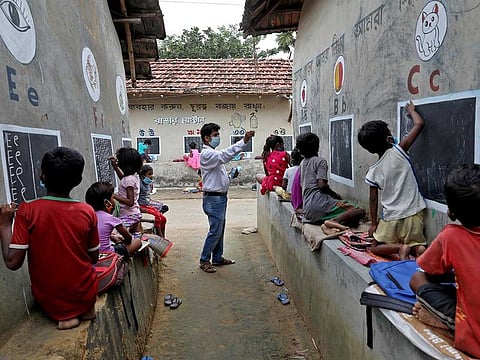 Deep Narayan Nayak, 34, a teacher, teaches children who do not have access to internet facilities and gadgets, in an open air class outside the houses with the walls converted into black boards following the closure of their schools due to the coronavirus disease (COVID-19) outbreak, at Joba Attpara village in Paschim Bardhaman district in the eastern state of West Bengal, India, September 13, 2021. 