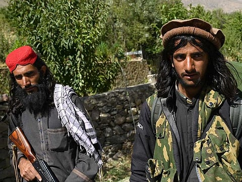 Taliban fighters walk along a road in Malaspa area, Bazark district, Panjshir Province on September 15, 2021, days after the Islamist group announced the capture of the last province resisting their rule.