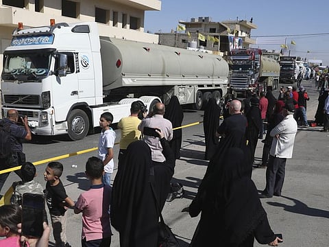 Hezbollah supporters celebrate as a convoy of tanker trucks carrying Iranian diesel crossed the border from Syria into Lebanon, arrive at the eastern town of Al Ain on  September 16, 2021. 