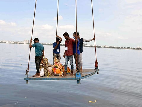 Volunteers carry idols of Ganesha in a crane for immersion in the Hussain Sagar Lake in Hyderabad.