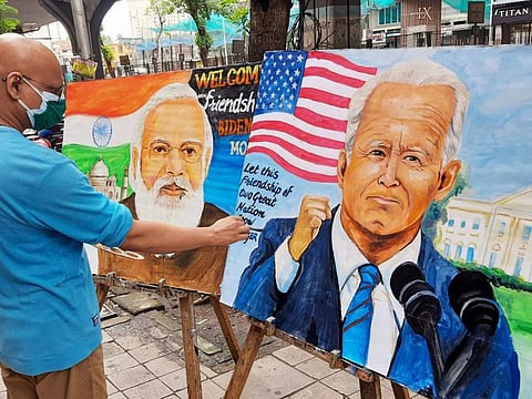 An artist paints the pictures of Prime Minister Narendra Modi and American President Joe Biden and sending wishes for better relations between both countries, in Mumbai on Thursday. 