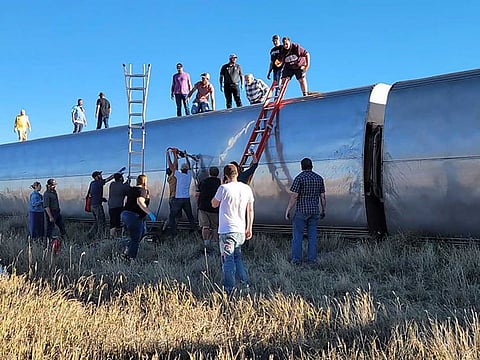 In this photo provided by Kimberly Fossen, people work at the scene of an Amtrak train derailment on Saturday, Sept. 25, 2021, in north-central Montana.
