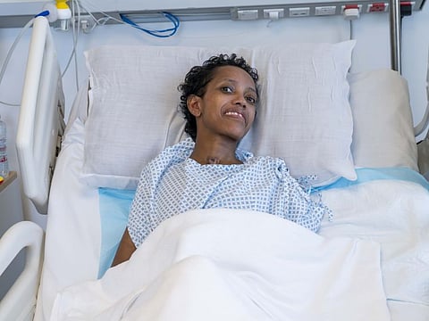 Tsige Geromi Guta smiles from her hospital bed at Aster Hospital in Qusais, Dubai.