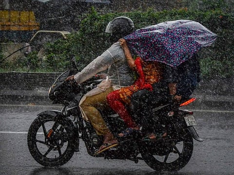 Motorists make their way amid heavy rains along a road in Hyderabad on September 27, 2021, the morning after cyclone Gulab made landfall between the coastal Indian states of Odisha and Andhra Pradesh. 