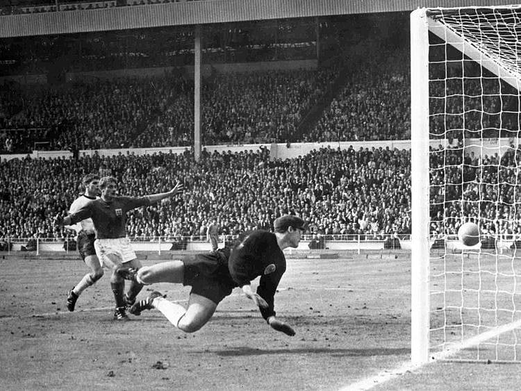 England's Roger Hunt raises his arms as Geoff Hurst scores England's third goal against West Germany