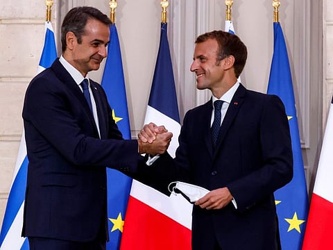 Greek Prime Minister Kyriakos Mitsotakis, left, and French President Emmanuel Macron shake hands after the signing of a new defence deal at The Elysee Palace on September 28, 2021 in Paris. 