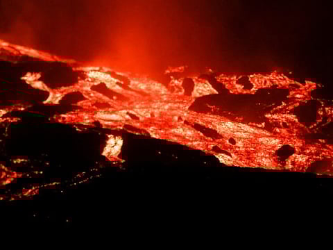 Lava flows and smoke rises following the eruption of a volcano on the Canary Island of La Palma, in Todoque, Spain, on September 28, 2021. 
