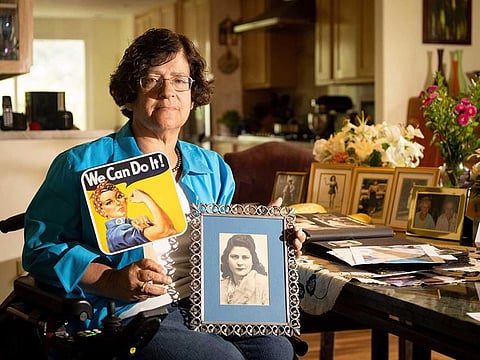Dorene Giacopini holds up a photo of her mother Primetta Giacopini while posing for a photo at her home in Richmond, Calif. on Monday, Sept 27, 2021.  Primetta Giacopini's life ended the way it began — in a pandemic. 