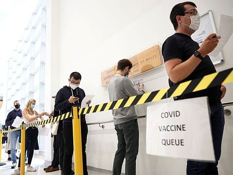 People queue to receive a dose of the Pfizer BioNTech vaccine at the Central Middlesex Hospital in London. 