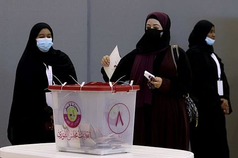 A woman casts her vote in the Gulf Arab state's first legislative elections for two-thirds of the advisory Shura Council, in Doha, on October 2, 2021. 