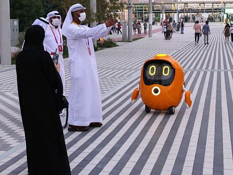 Visitors take pictures of a robot outside the Dutch pavilion at the Expo 2020 Dubai