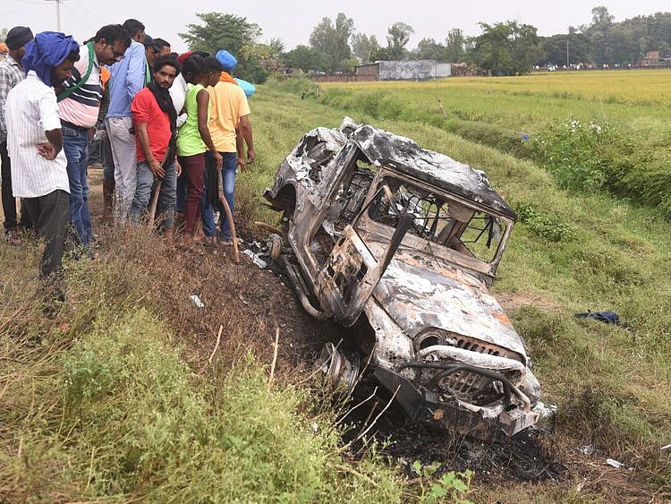 People take a look at the vehicle which was destroyed in violence during farmers' protest at Lakhimpur Kheri district in UP, India