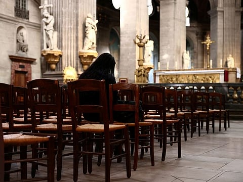 A woman prays inside the Saint-Sulpice church in Paris. France's Catholic Church is already reeling from several sexual scandals in schools it runs and accusations of longtime sexual abuse made against Abbe Pierre, once an icon of the defence of the poor who died in 2007.