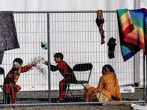Children play with stones at an Afghan refugees camp on Joint Base McGuire Dix Lakehurst, N.J., on Monday, Sept. 27, 2021. The camp currently holds about 9,400 Afghan refugees and has a capacity to hold up to 13,000.