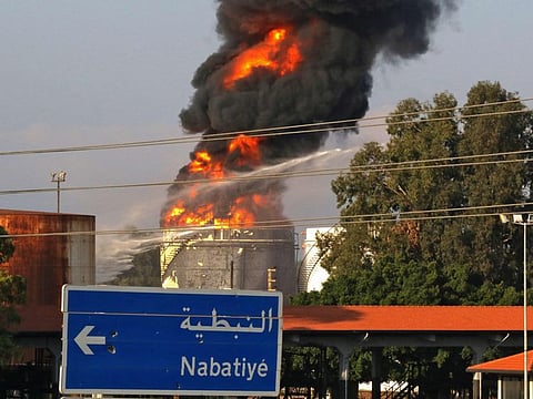 Firefighters try to extinguish a fire in one of the tanks at the Zahrani oil facility in southern Lebanon on October 11, 2021, sparking alarm as the country grapples with dire hydrocarbon shortages. 