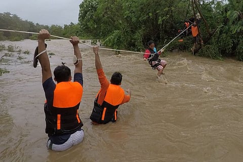Rescuers evacuating residents from their homes near a swollen river due to heavy rains brought about by Tropical Storm Kompasu in Gonzaga town, Cagayan province, north of Manila. 