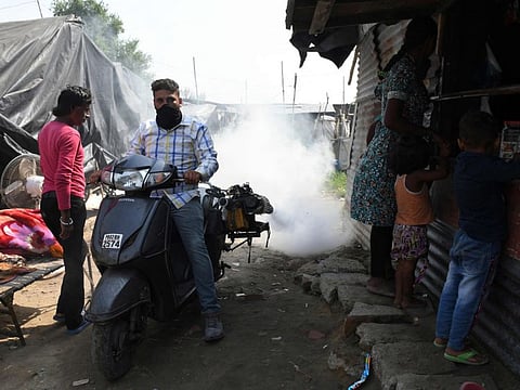 A worker of the Municipal Corporation Amritsar (MCA) sprays mosquito repellent as part of a prevention campaign against dengue fever in a slum area in Amritsar on October 10, 2021.  