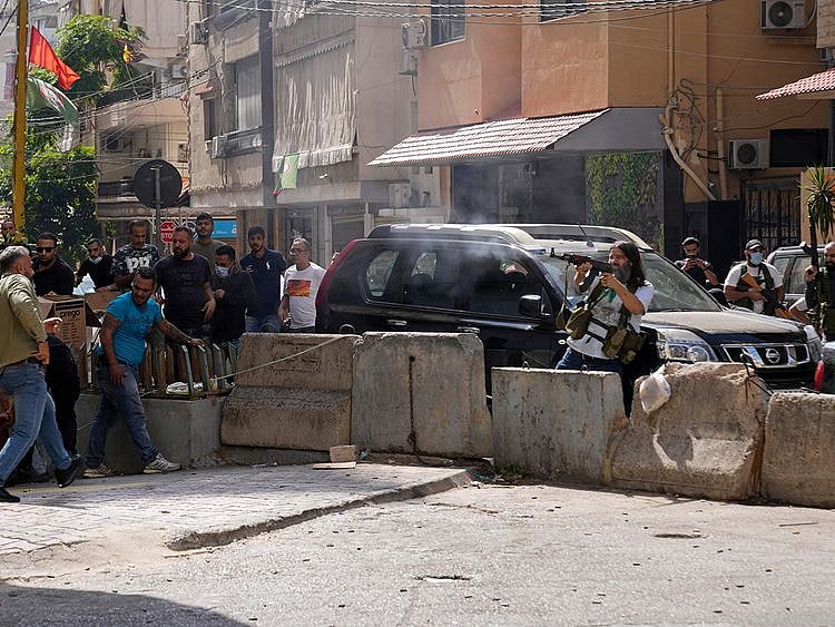  Supporters of a Shiite group allied with Hezbollah fire during armed clashes that erupted during a protest in the southern Beirut suburb of Dahiyehon October 14, 2021.
