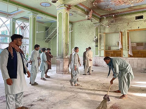 Afghan men inspect the damage in a mosque in Kandahar on October 15, 2021.