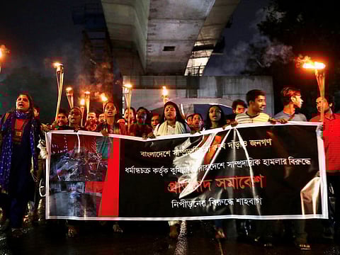 Bangladeshi activists take out a torch procession demanding justice for the violence against Hindu communities during Durga Puja festival in Dhaka on October 18, 2021. 