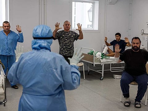 A medic and COVID-19 coronavirus patients perform breathing exercises as part of physiotherapy in the Moscow Sklifosovsky emergency hospital in Moscow 