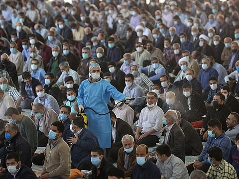 A health official sprays disinfectant during Tehran's first Friday prayer after a nearly two-year break due to COVID-19 pandemic, in Tehran on October 22, 2021. 