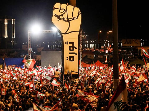 Lebanese demonstrators wave national flags during anti-government protests in the heart of Beirut in this November 10, 2019 file photo.