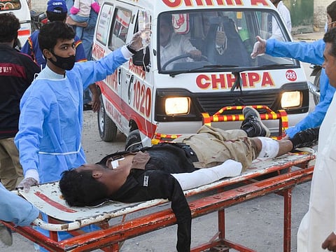 Paramedics shift an injured policeman into a hospital after a bomb blast near a gate of the University of Balochistan in Quetta on October 18, 2021, which killed one police officer and left at least 17 other people wounded. 