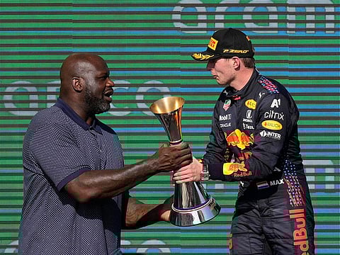 Shaquille O'Neal, left, hands the winner's trophy to Red Bull driver Max Verstappen, of the Netherlands, at the Formula One U.S. Grand Prix auto race at Circuit of the Americas, Sunday, Oct. 24, 2021, in Austin, Texas.