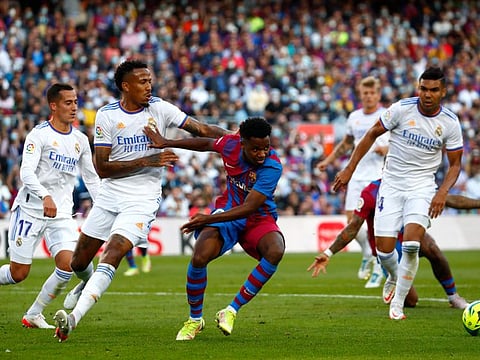 Real Madrid's Eder Militao (left) challenges Barcelona's Ansu Fati (centre), during the Spanish La Liga at the Camp Nou stadium in Barcelona, Spain.