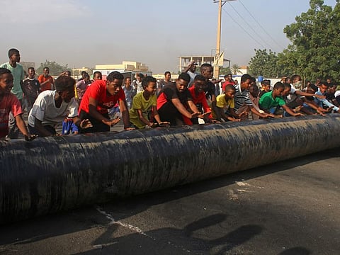 Sudanese erect barricades during their protest on October 26, 2021 in the Al Shajara district in southern Khartoum. 