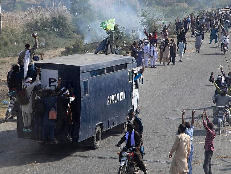  Supporters of Tehreek-e-Labiak Pakistan, a banned Islamist party, celebrate after capturing a police vehicle during their protest march toward Islamabad, on a highway in the town of Sadhuke, in eastern Pakistan, on Wednesday, October 27, 2021.