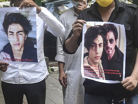 Fans of Bollywood actor Shah Rukh Khan hold posters in support of Aryan Khan outside Bombay High Court in Mumbai on October 26, 2021.