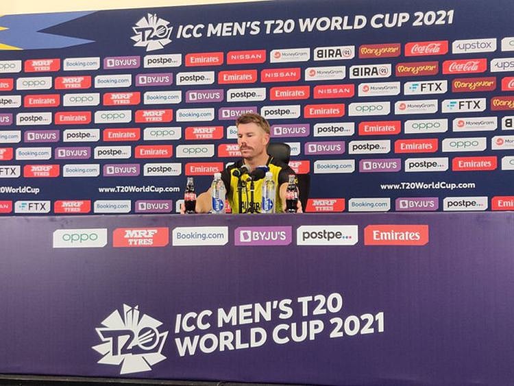 David Warner removes the Coke bottles for a joke